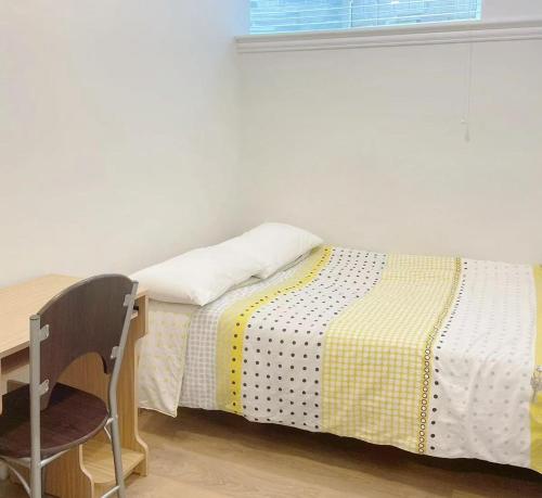 a bed in a room with a desk and a chair at Beautiful place with Kitchen, Washing Machine, Internet near UBC, beach and DT in Vancouver