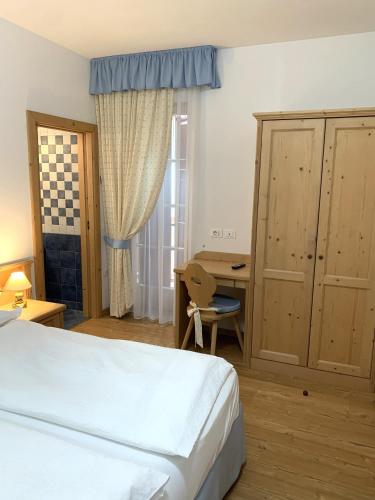 a hotel room with a bed and a desk and a desk at Bed & Breakfast SISSI in Commezzadura