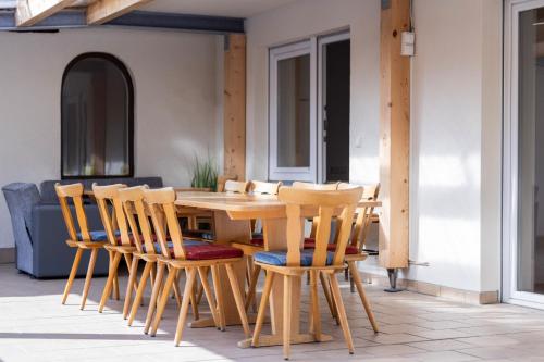 a wooden table and chairs on a patio at Zum Hüttenklaus - 12 Personen Gruppenunterkunft in den Bergen mit eigenem Badezuber in Bad Hindelang