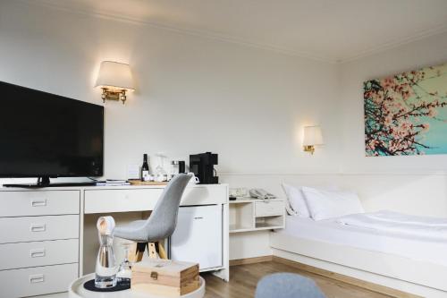 a bedroom with a desk with a chair and a bed at Das Parkhotel in Bad Wörishofen