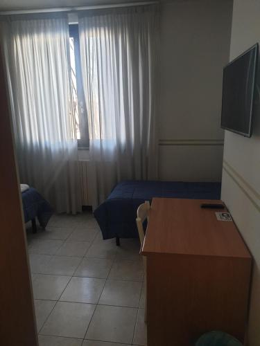 a room with two beds and a desk and a window at Il Piccolo Golf in Muggiò