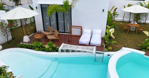 a house with a swimming pool and a patio at Ôkeanos Boutique Hotel - Uluwatu Ungasan in Uluwatu