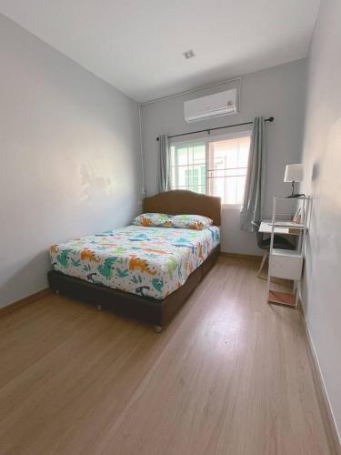 a bedroom with a bed and a window and a desk at DJ Home in Ban Ko