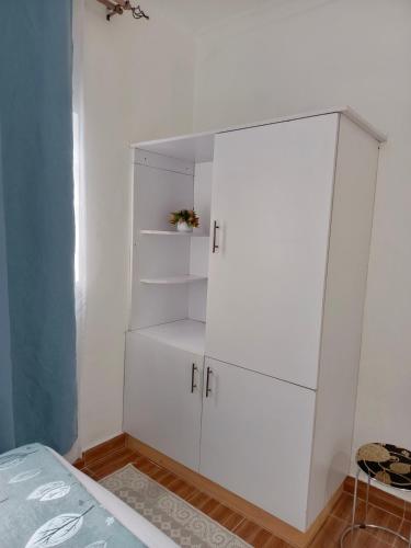 a white cabinet in a room with a bed at The Kioka gardens 4 bedroom home in Nanyuki