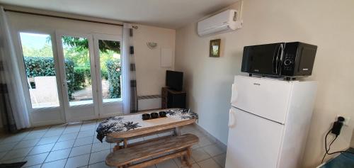 Il comprend une cuisine équipée d'un réfrigérateur et une télévision. dans l'établissement Studio 30 m2 climatisé calme, à Eccica-Suarella