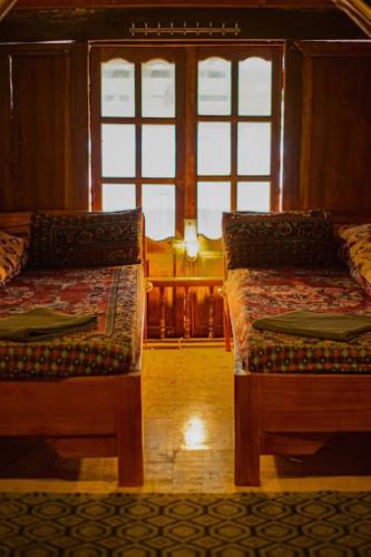 two beds sitting in a room with windows at Long Cổ Trấn Homestay in Dồng Văn