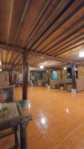 a large room with a wooden floor and wooden beams at Long Cổ Trấn Homestay in Dồng Văn