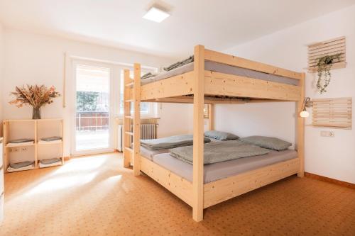 a bedroom with two bunk beds in a room at Zum Hüttenklaus - 12 Personen Gruppenunterkunft in den Bergen mit eigenem Badezuber in Bad Hindelang