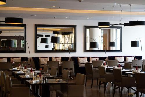 a dining room with tables and chairs and mirrors at Waldorf Astoria Berlin in Berlin