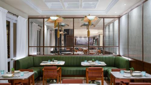 a restaurant with a green couch and tables at Hilton Mumbai International Airport Hotel in Mumbai