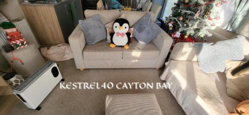 a toy penguin sitting on a couch in a living room at Cayton Bay Kestrel40 in Cayton