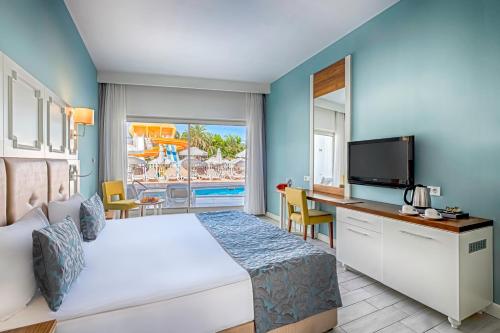 a hotel room with a bed and a desk and a television at WELL PALACE SIDE in Side