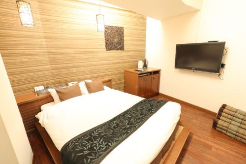 a hotel room with a bed and a flat screen tv at HOTEL B-Girl in Tokyo