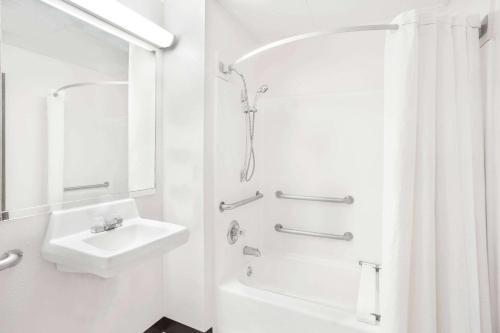 a white bathroom with a sink and a shower at Super 8 by Wyndham Galesburg in Galesburg