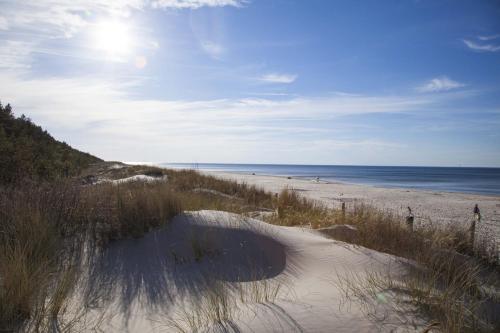 a view of a beach from a sand dune at Hotel i Apartamenty Gorzelanny Dźwirzyno in Dźwirzyno
