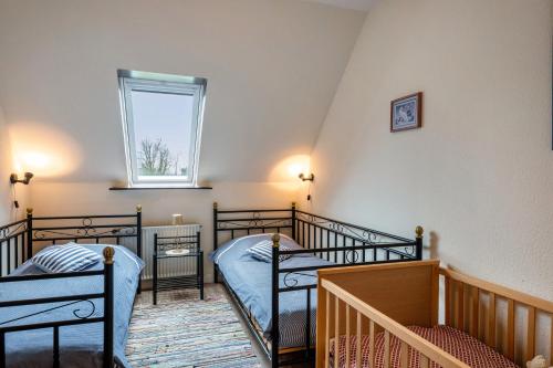 a bedroom with two bunk beds and a window at Ferienwohnungen Kastenmüller in Westerdeichstrich