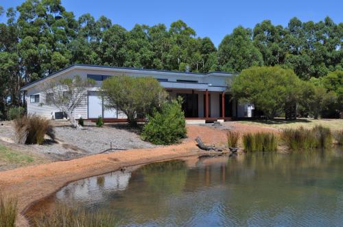 a house with a pond in front of it at Wharfedale in Wilyabrup