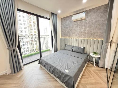 a bedroom with a bed and a large window at LEÉ BOISE Hà Nội - Luxury Apartment in Vinhomes Times City in Hanoi