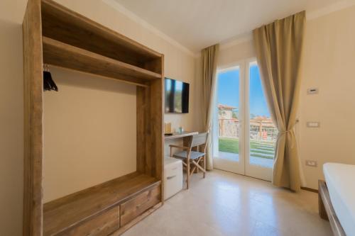 a bedroom with a sliding door leading to a balcony at BnB Il Grecale in Lacona