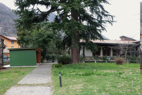 a house with a tree in the yard at Villa Paradis B&B in Airuno