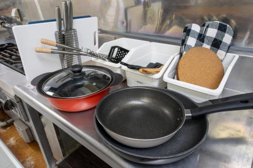 a kitchen counter with a frying pan and other kitchen utensils at Cottage Alice in Hachimantai