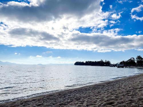 a beach with a cloudy sky and the ocean at Pension B,B, Dylan - Vacation STAY 30973v in Otsu