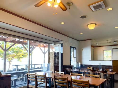 a dining room with tables and chairs and windows at Pension B,B, Dylan - Vacation STAY 30973v in Otsu