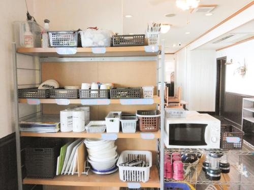 a kitchen shelf with dishes and a microwave at Pension B,B, Dylan - Vacation STAY 30973v in Otsu