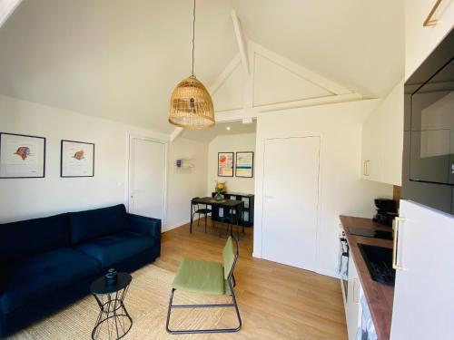 a living room with a blue couch and a table at Le studio in Dinard