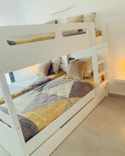 two bunk beds in a white room with at Casa Noyas Oasis Beach in Guardamar del Segura