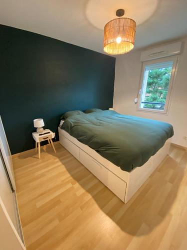 une chambre avec un lit et un mur végétal dans l'établissement Appartement à 400m de la plage - 6 couchages, à Neufchâtel-Hardelot