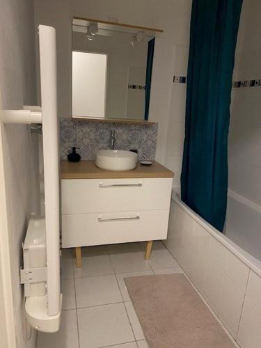 une salle de bain avec un lavabo et un miroir dans l'établissement Appartement à 400m de la plage - 6 couchages, à Neufchâtel-Hardelot