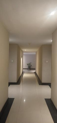 an empty hallway with a potted plant in the distance at Nirmala Hotel & Convention Centre in Denpasar