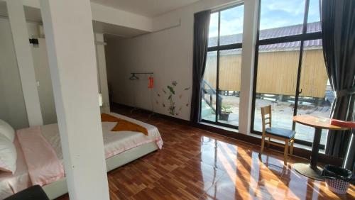 a bedroom with a bed and a large window at Waterfall Guesthouse1 in Phumĭ Kaôh Rŏng