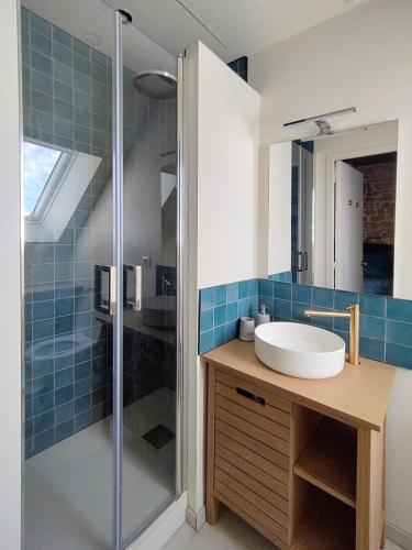 une salle de bain avec un lavabo et une douche dans l'établissement Maison de pêcheur en bord de mer, à Grandcamp-Maisy