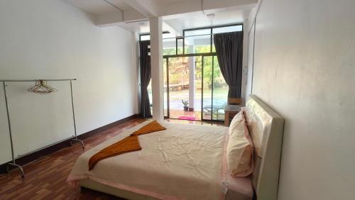 a bedroom with a bed and a large window at Waterfall Guesthouse1 in Phumĭ Kaôh Rŏng