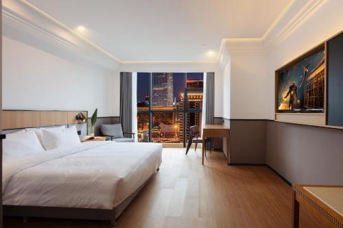 a hotel room with a bed and a view of a city at Mcsrh Hotel-Chongqing Guanyinqiao in Chongqing