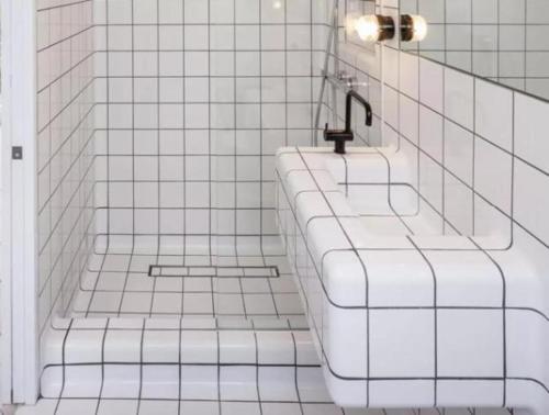 a white tiled bathroom with a tub and a sink at Chatillon Citea Express Chambre chez l'habitant Chatillon métro pour nuitée avec accès direct Paris centre et Espace limité en journée Paris sans nuitée accès limité 8h00-19h00 pour dépôt bagages in Paris