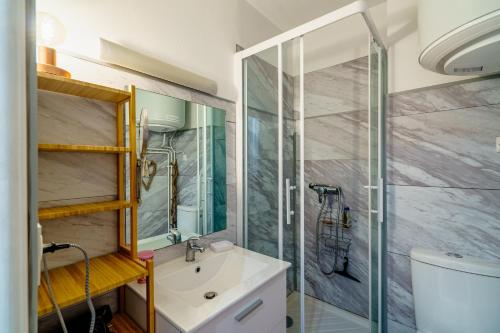 une salle de bain avec un lavabo et une douche dans l'établissement La Cabine Bleue - A 30 mètres de la plage, à Bénodet