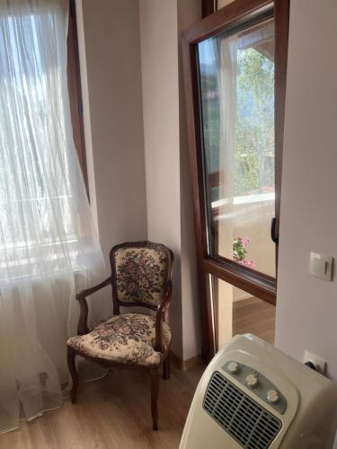 a room with a chair next to a window at Guest House Kalina in Sapareva Banya