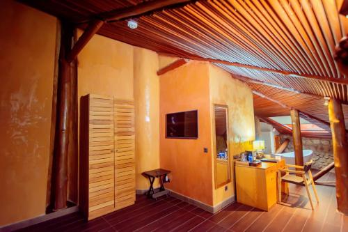 a living room with a wooden ceiling and a desk at Trois Ore Residences & Green Earth Bistro in Ibadan