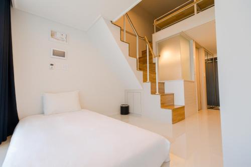 a bedroom with a white bed and a staircase at Blue Ocean Hotel 3 in Incheon