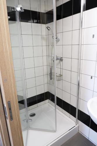 a shower with a glass door in a bathroom at Dom Studencki Arka in Wrocław