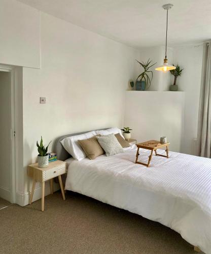a bedroom with a large white bed and a table at Henwick Loft in Henwick