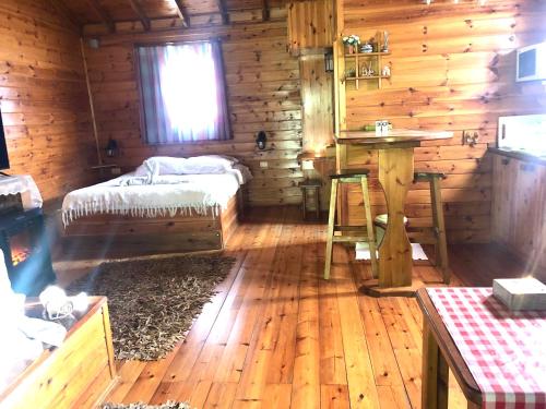 a room with a bed and a table in a log cabin at בלב הגורן belevhagoren in Goren