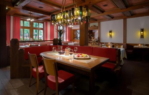 a restaurant with a wooden table and red booths at Ringhotel Winzerhof in Rauenberg