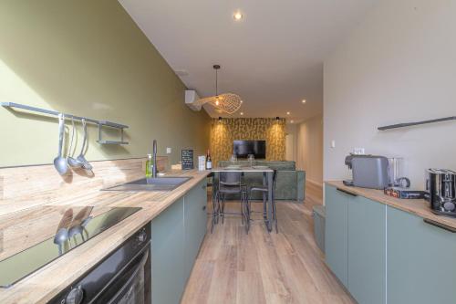 une cuisine avec un évier et un plan de travail dans l'établissement L 'Elegant - travelhome - 50m de la gare, à Villefranche-sur-Saône