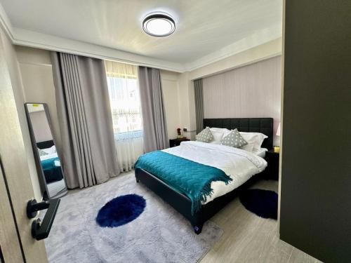 Un dormitorio con una cama y una ventana grande. en Luxury Urban Escape in kilimani , Workspace, en Nairobi