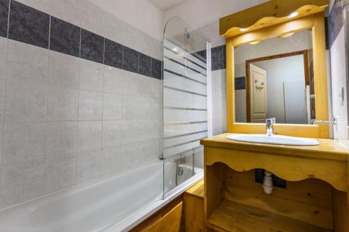une salle de bain avec un lavabo, un miroir et une baignoire dans l'établissement Résidence Les Hauts De Preclaux - Spacieux logement pour 8 personnes aux Orres 1800 MAE-6891, aux Orres