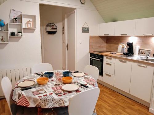 - une cuisine avec une table et des bols dans l'établissement Sea Bird parking draps fournis piscine partagée, à Arzon